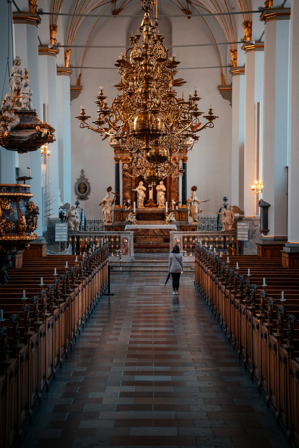 Una persona caminando por un largo pasillo en una iglesia