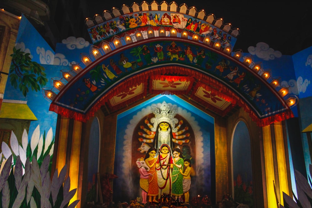 a brightly lit shrine with a statue of a woman and two children