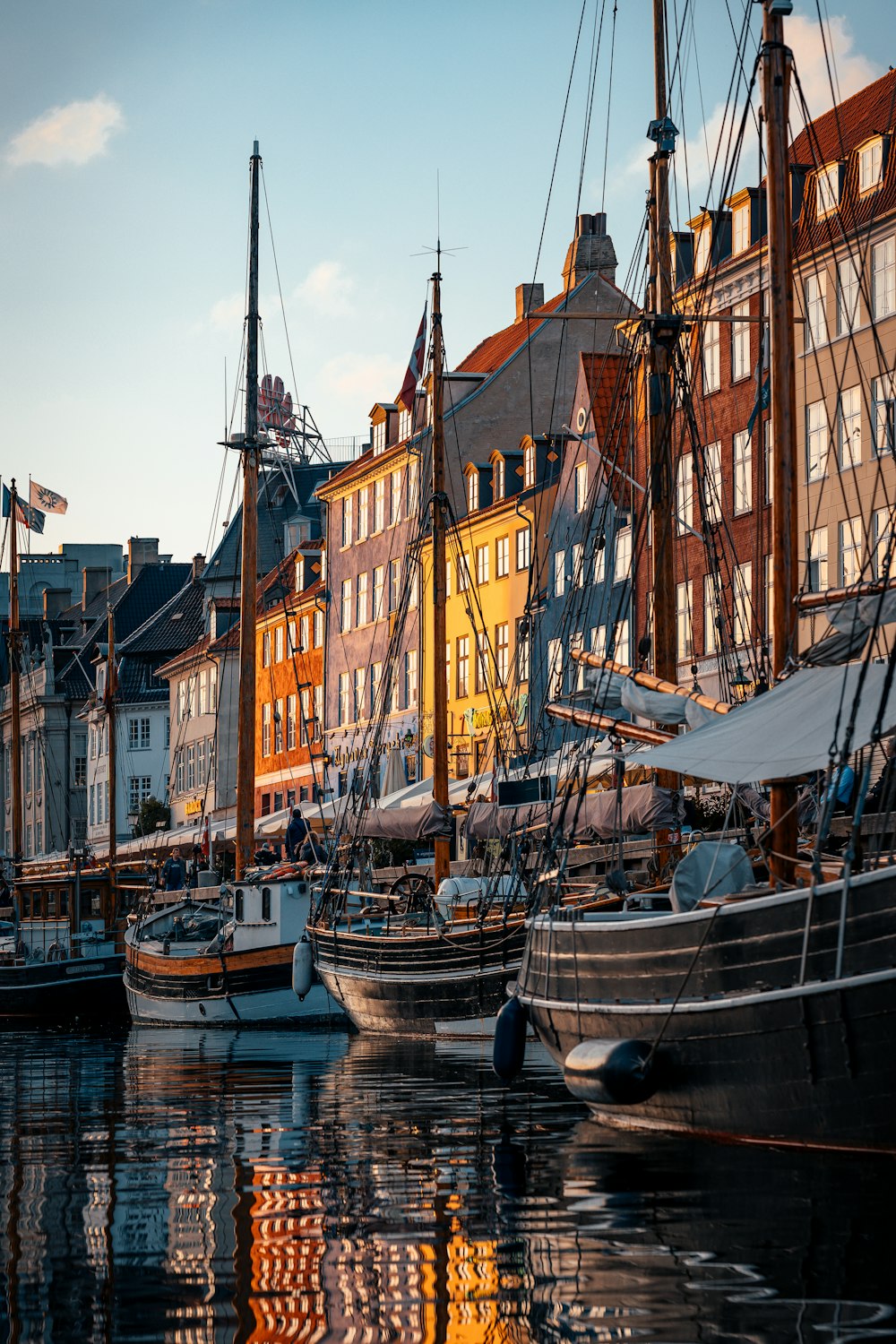 a harbor filled with lots of boats next to tall buildings