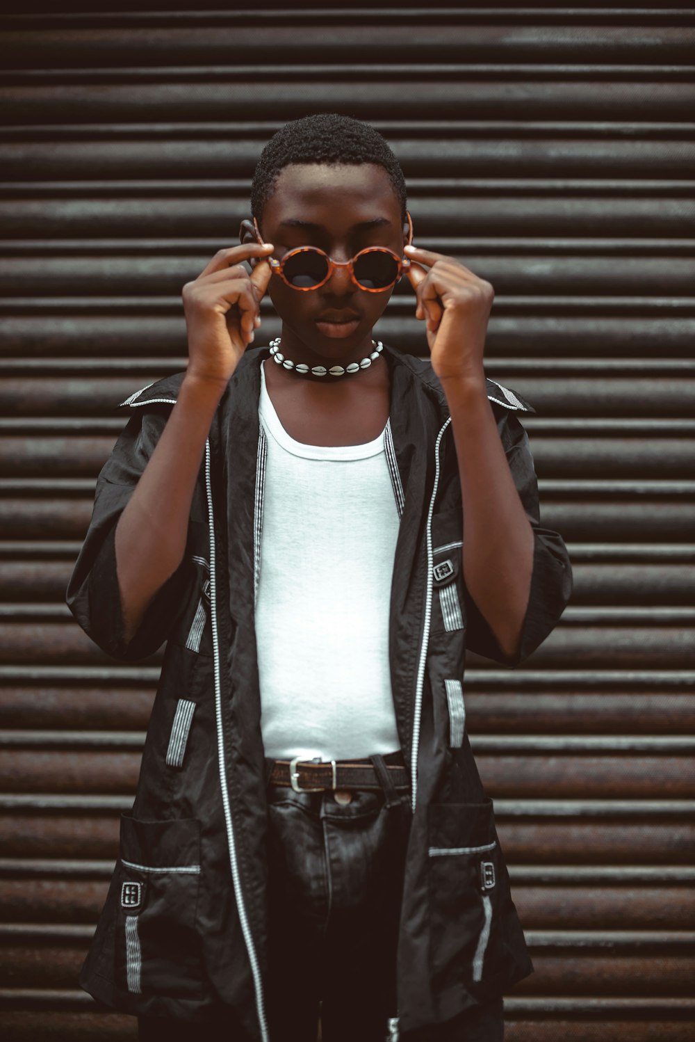 a young man wearing a black jacket and sunglasses