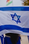 a woman holding a flag with a star of david on it