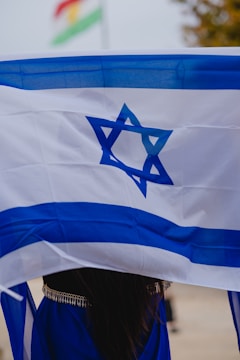 a woman holding a flag with a star of david on it