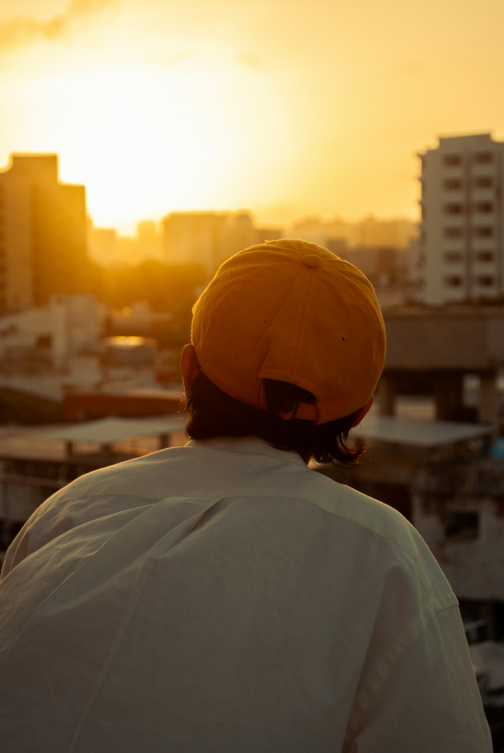 a person wearing a yellow hat looking at the sunset