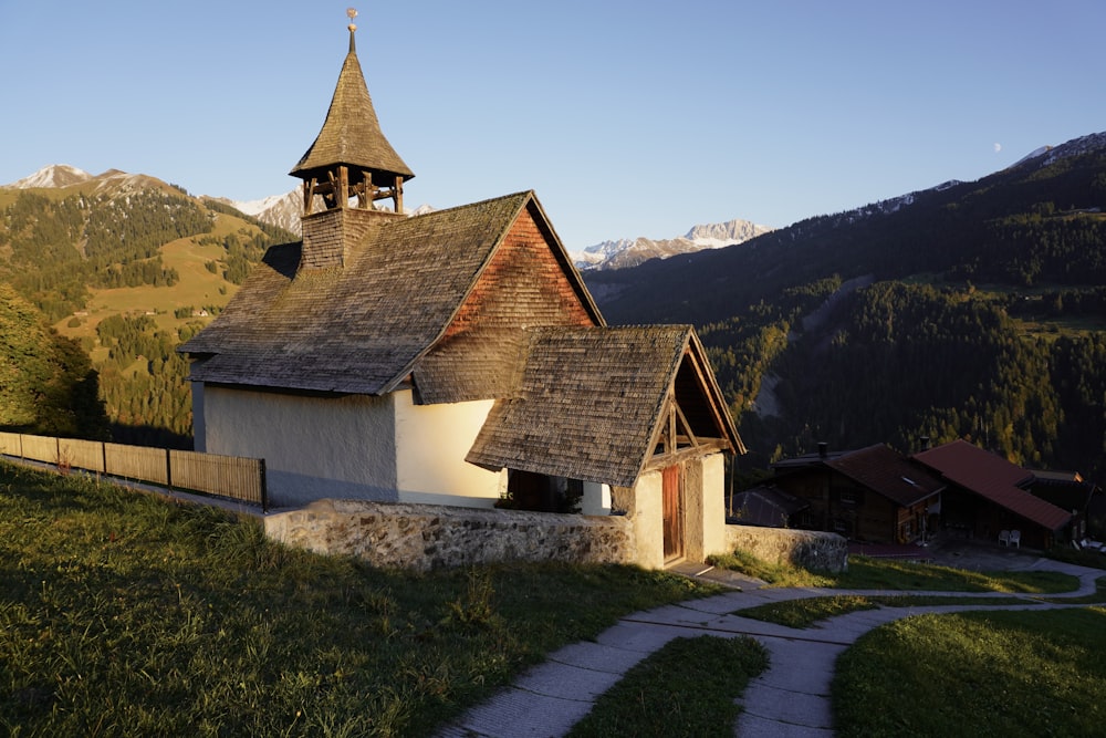 a small church with a steeple on top of a hill