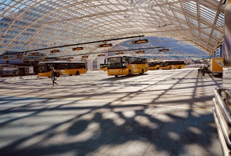 a group of buses parked inside of a train station