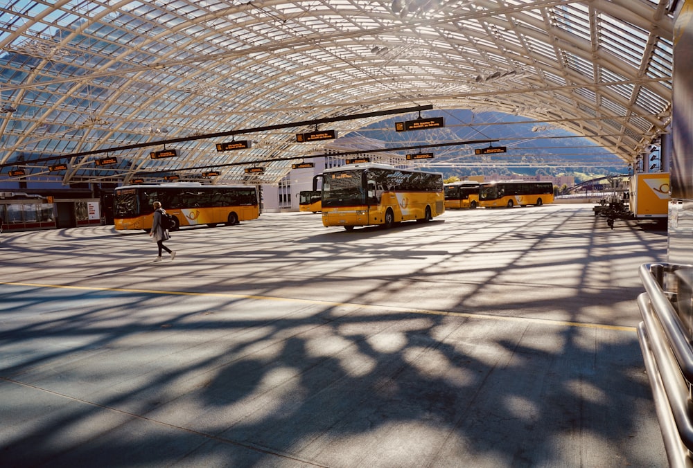 um grupo de ônibus estacionados dentro de uma estação de trem