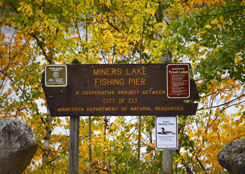 a sign on a pole in front of some trees