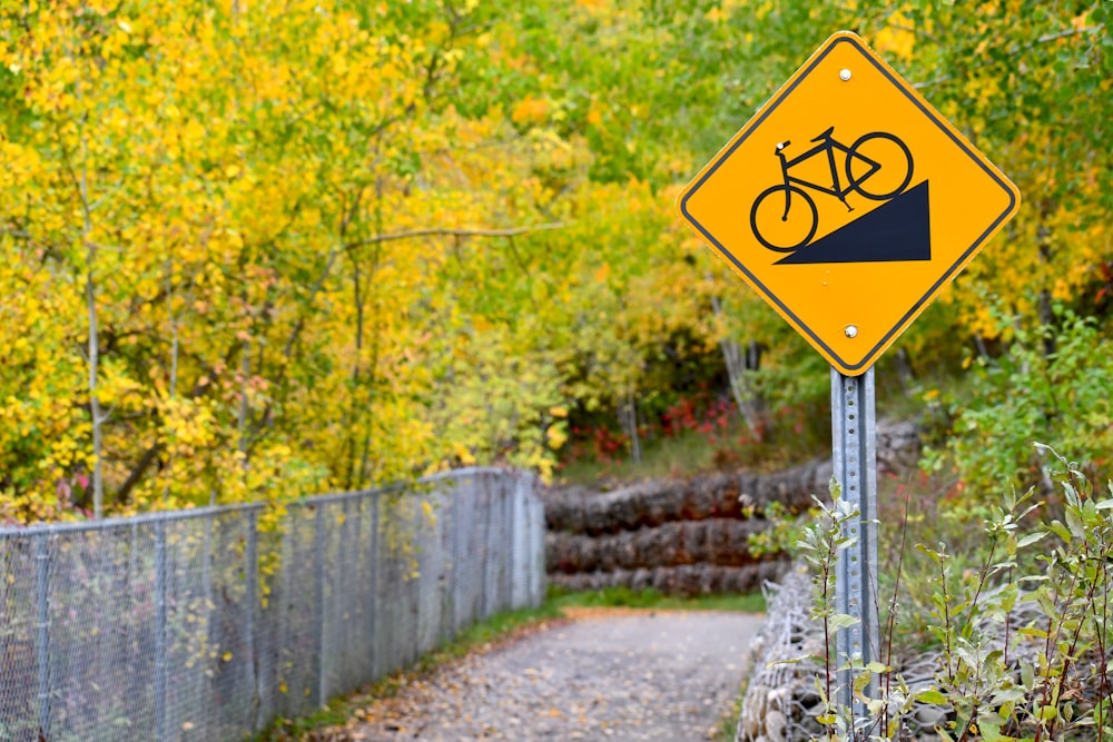 a yellow sign with a black triangle on it