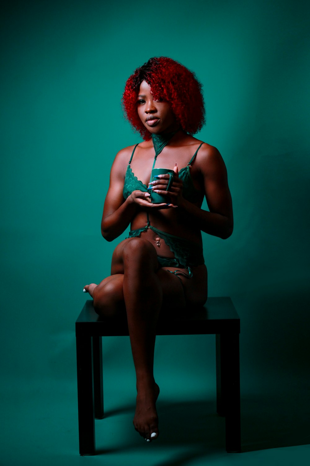 a woman with red hair sitting on a stool