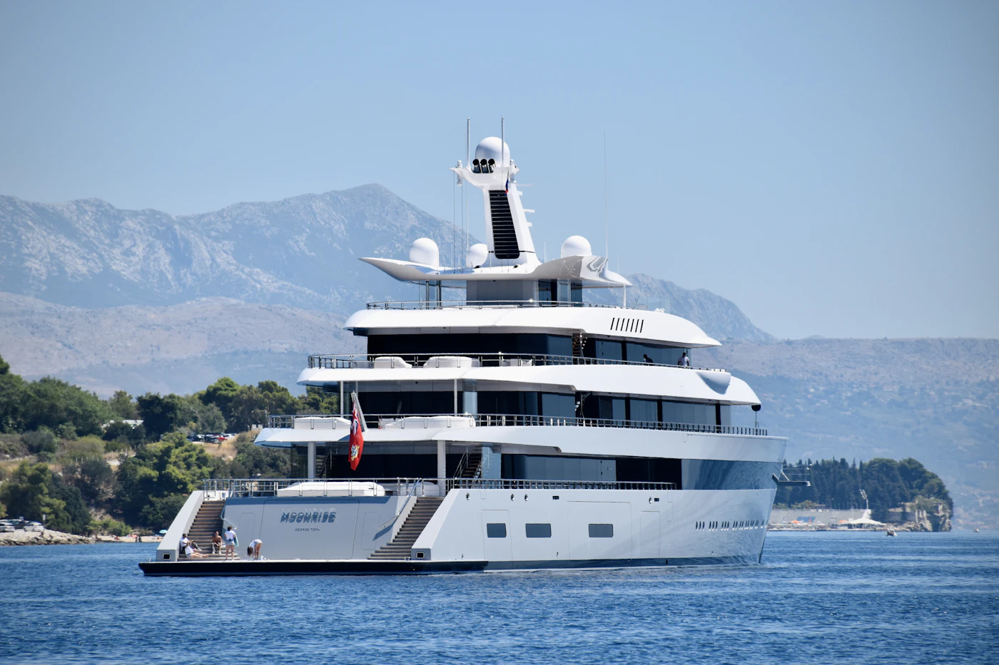 A luxury yacht anchored on the open Adriatic beneath coastal mountains