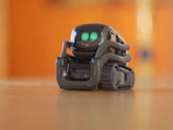 Compact telepresence robot navigating a high-tech laboratory environment.