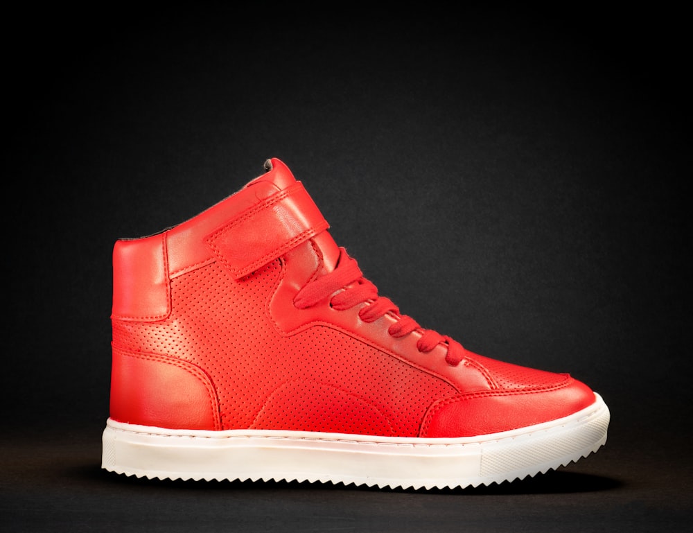 a red high top sneaker on a black background