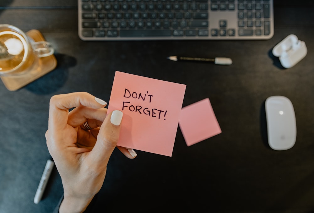 a person holding a note that says don't forget