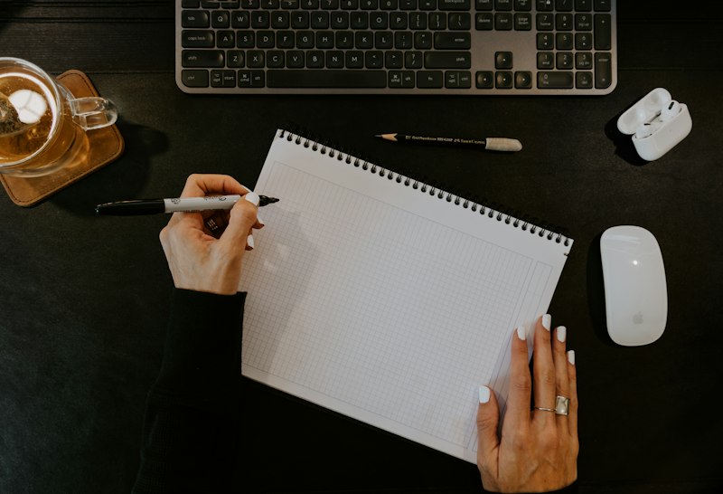 Hand writing in a blank notebook