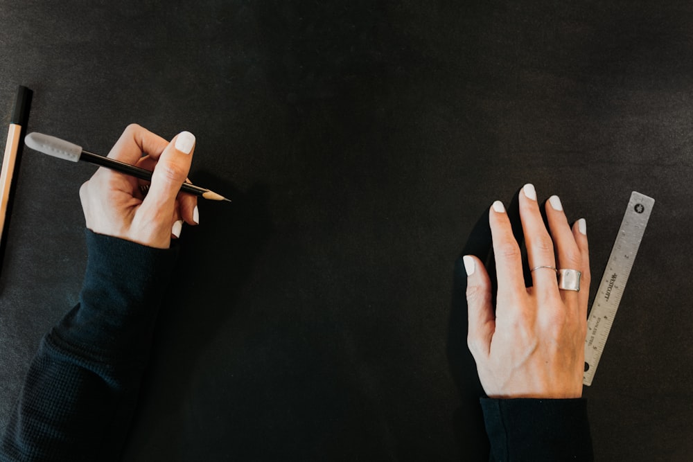 a woman is holding a pencil and a ruler