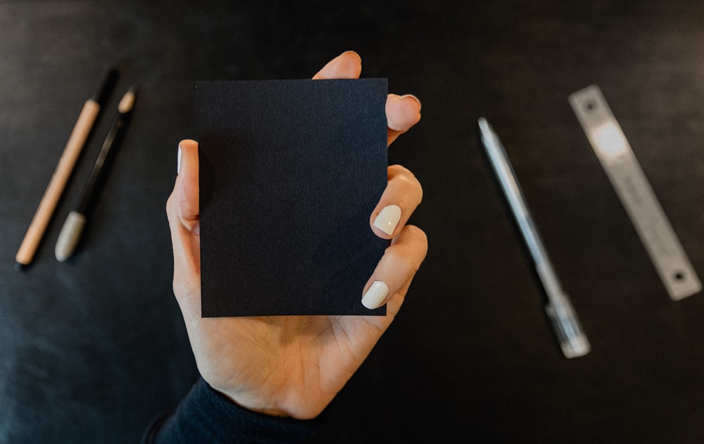 a person holding a piece of black paper