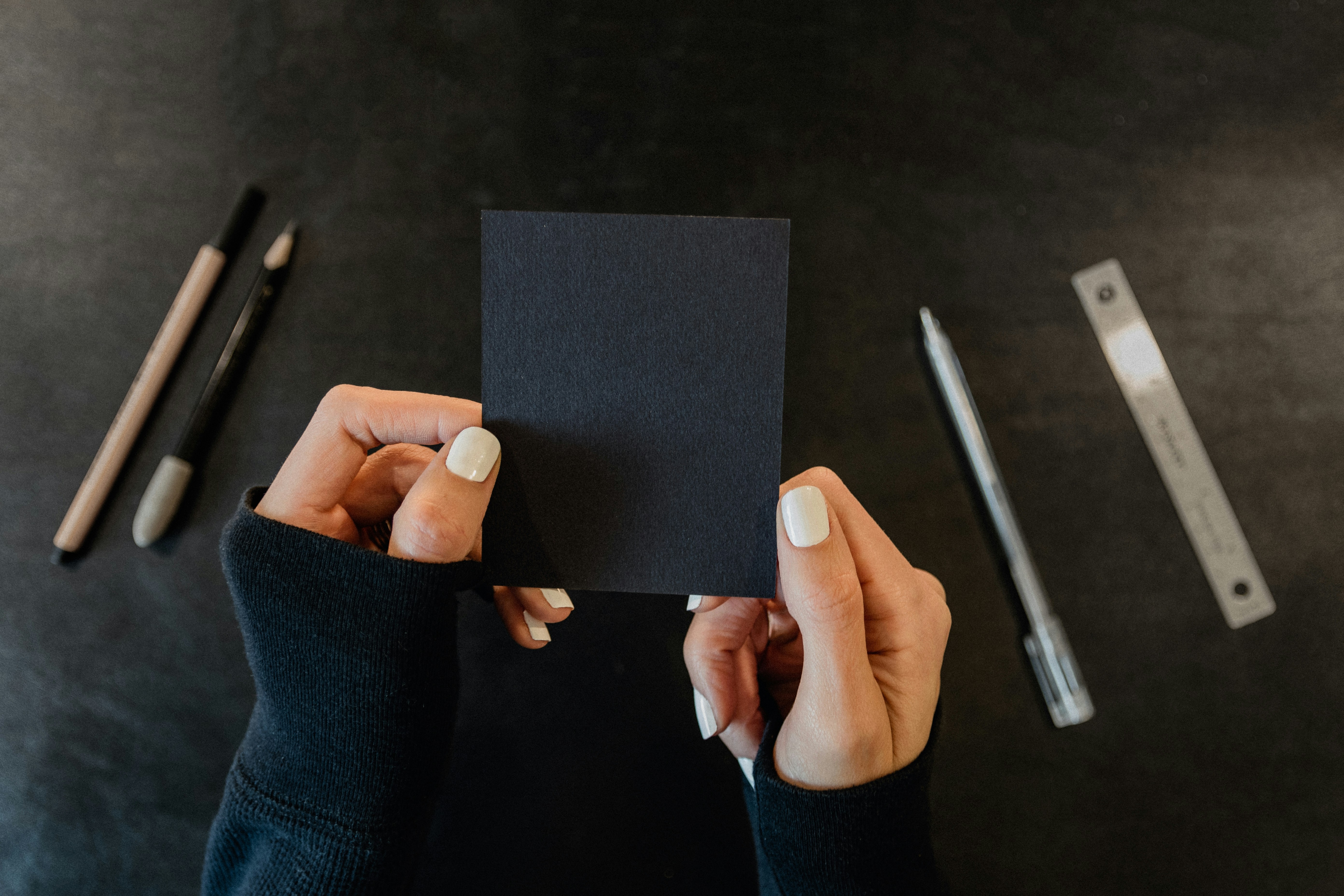 a person holding a piece of black paper