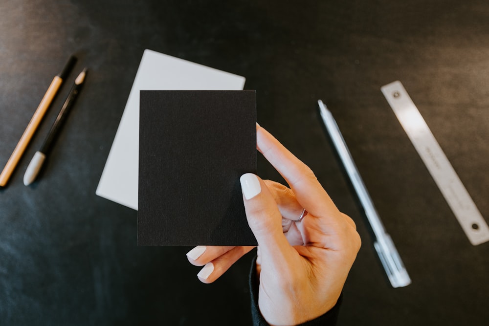 a person holding a piece of black paper