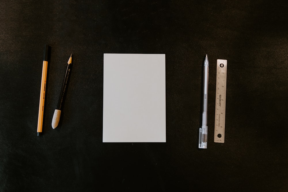 a piece of paper, a pencil, and a ruler on a table