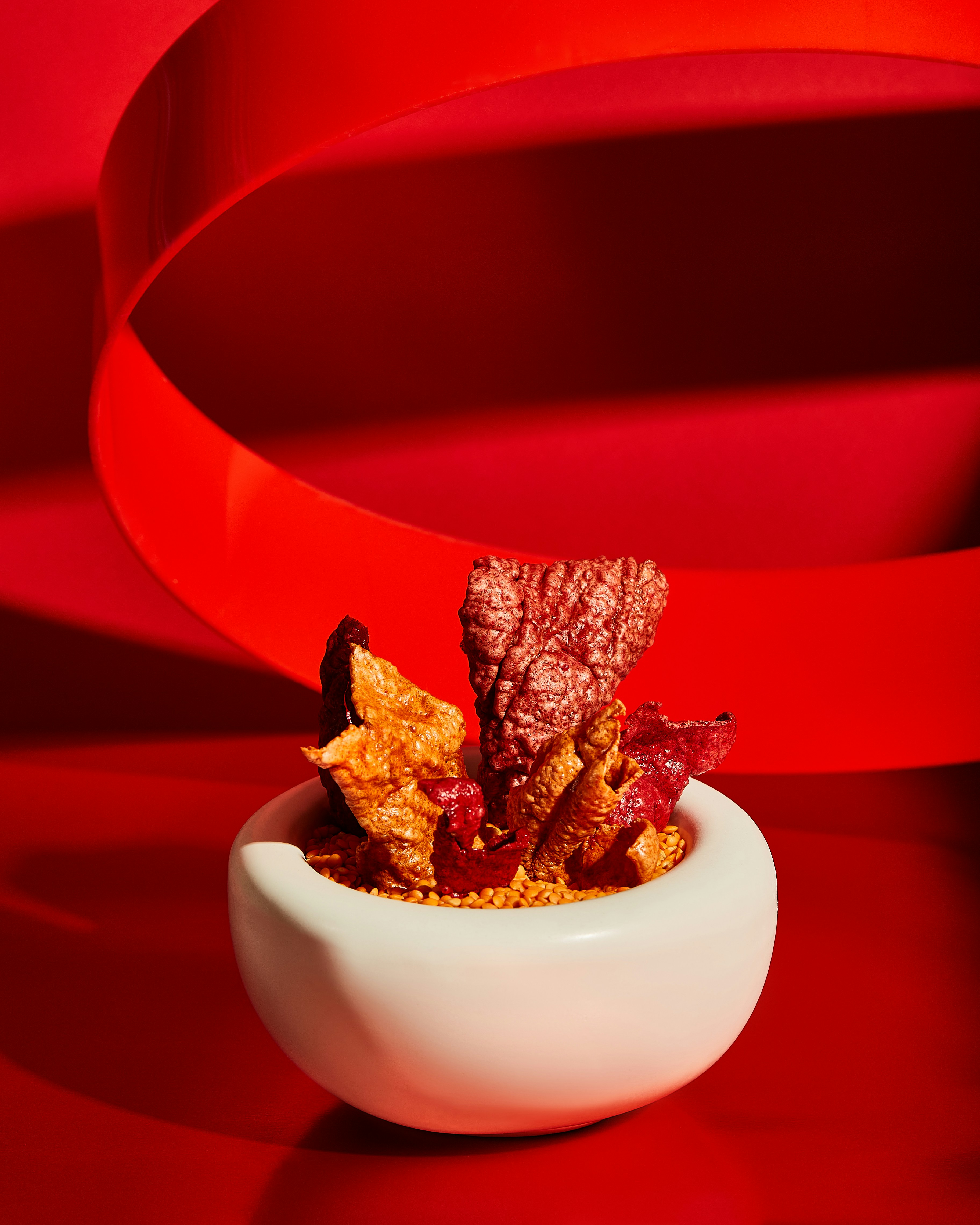 a white bowl filled with food on top of a red table