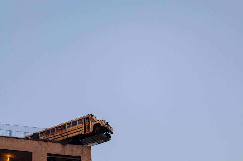 um ônibus escolar que está sentado em cima de um prédio