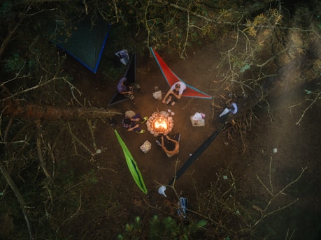 a group of people sitting around a campfire