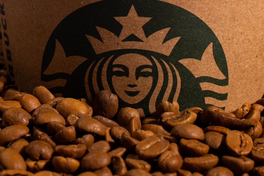 Une tasse Starbucks entourée de grains de café torréfiés