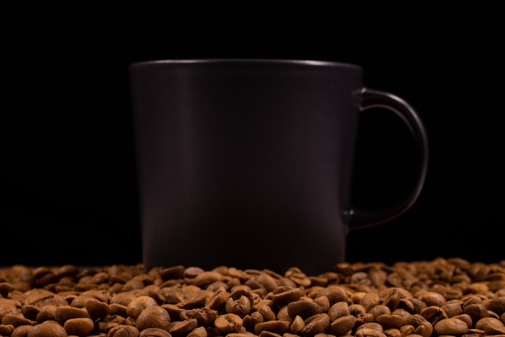 a coffee cup sitting on top of a pile of coffee beans