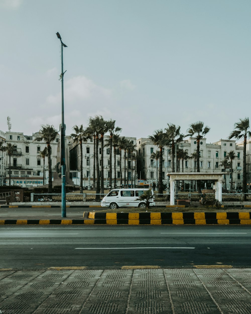 a white van driving down a street next to tall buildings