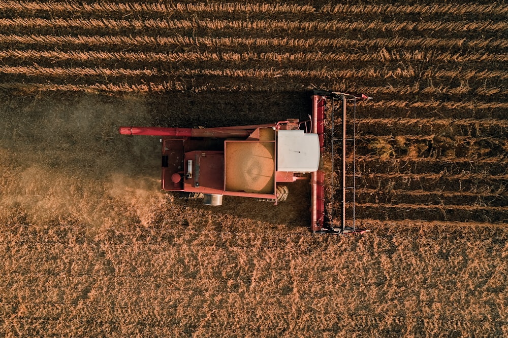 Un tracteur rouge traverse un champ