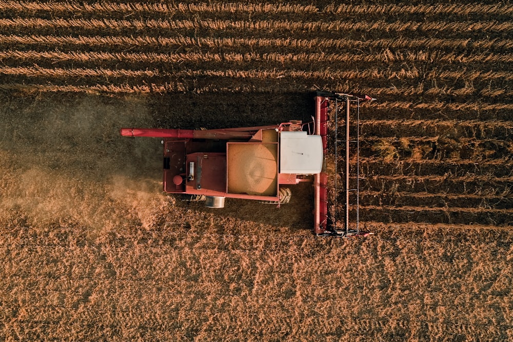 a red tractor is driving through a field