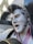 A statue of a man with slicked-back hair holding a guitar is captured. The sculpture features detailed facial expressions and vintage attire, emphasizing a 1950s rock and roll style.