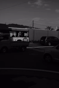 a black and white photo of a bus and cars