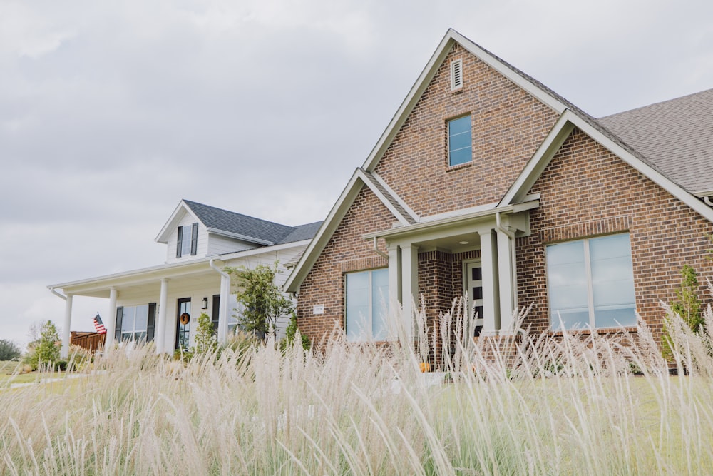 a brick house with tall grass in front of it