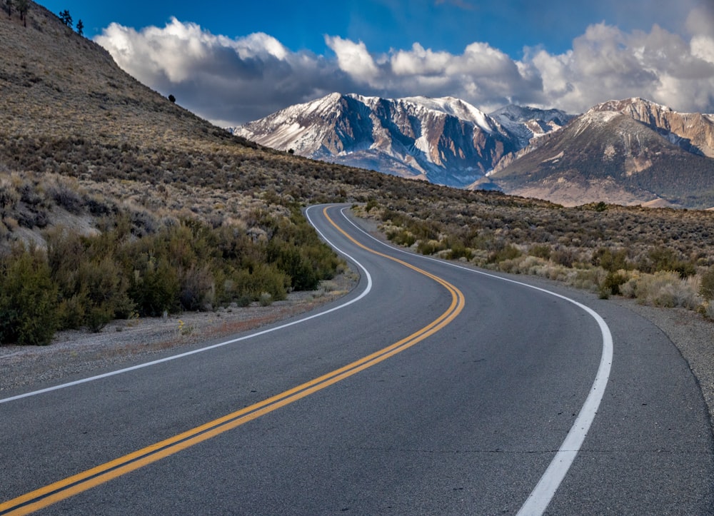 a curved road with mountains in the background