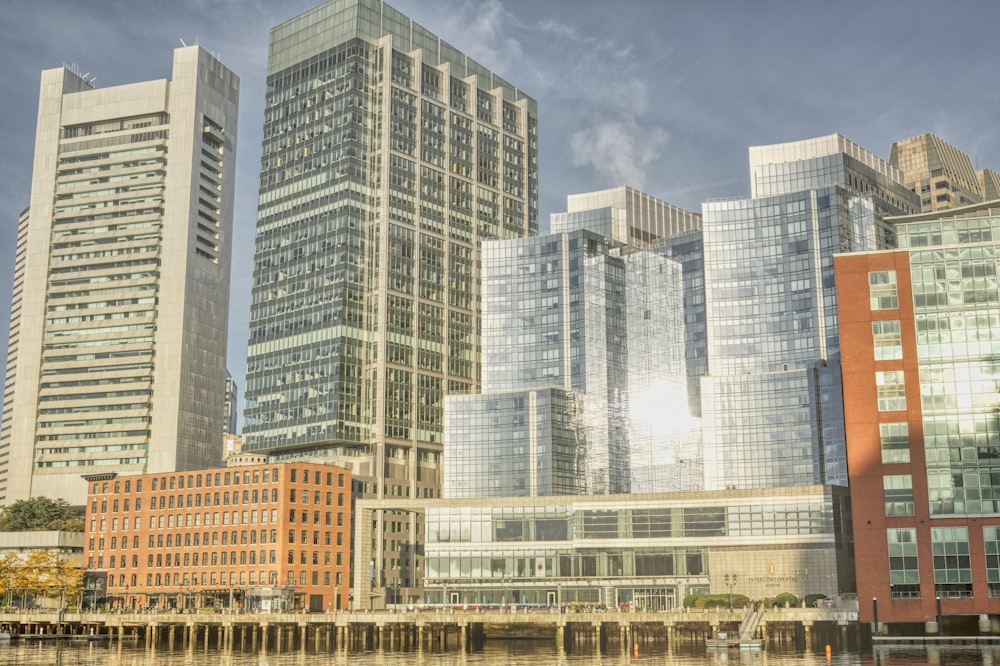 a group of tall buildings next to a body of water