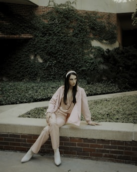 a woman sitting on a ledge in front of a building