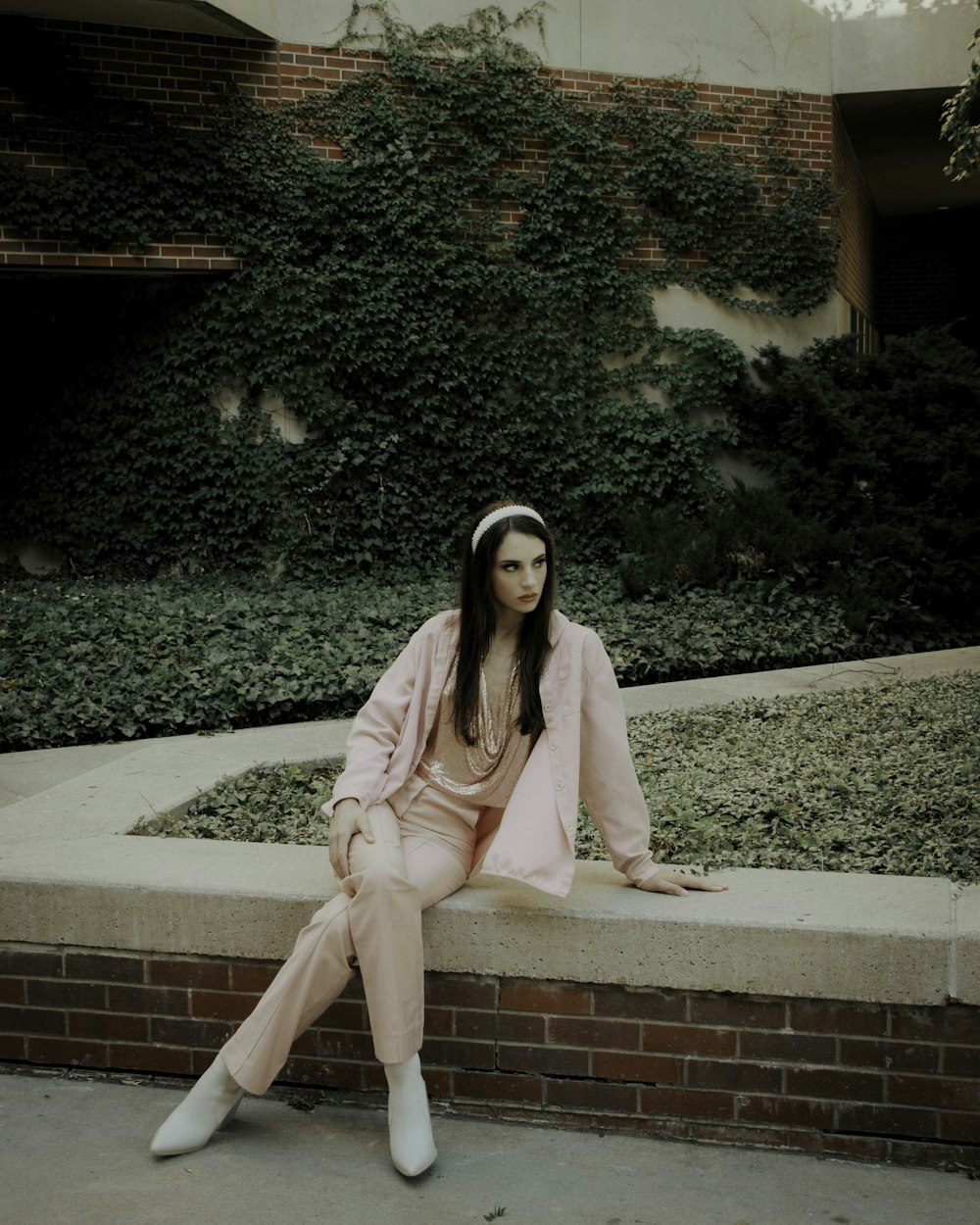 a woman sitting on a ledge in front of a building