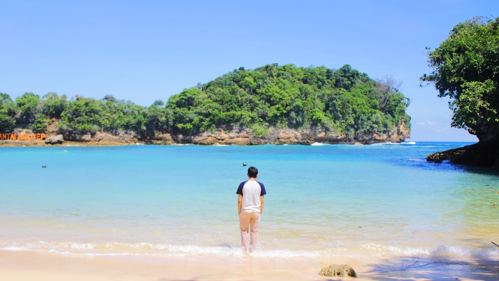 uma pessoa em pé na água em uma praia