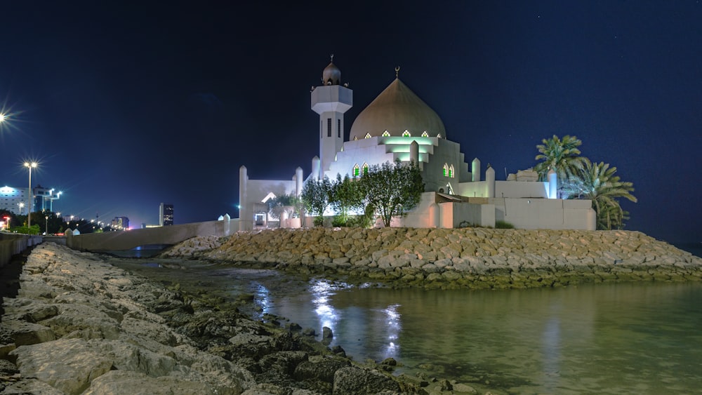 a large white building sitting on top of a rocky shore