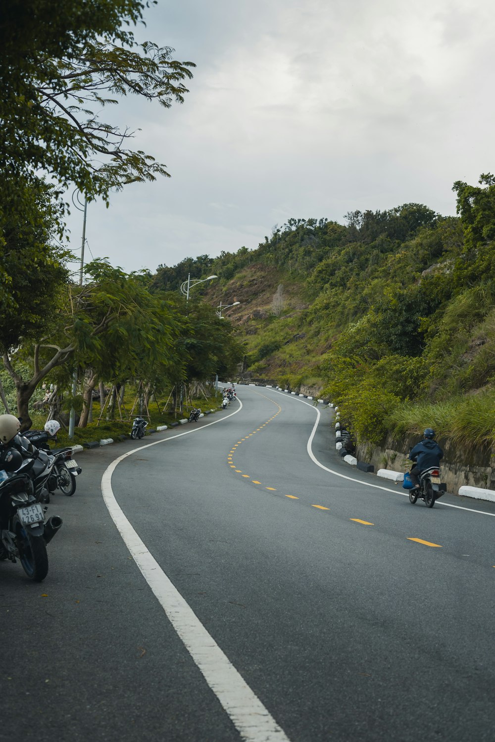 a couple of people riding motorcycles down a curvy road
