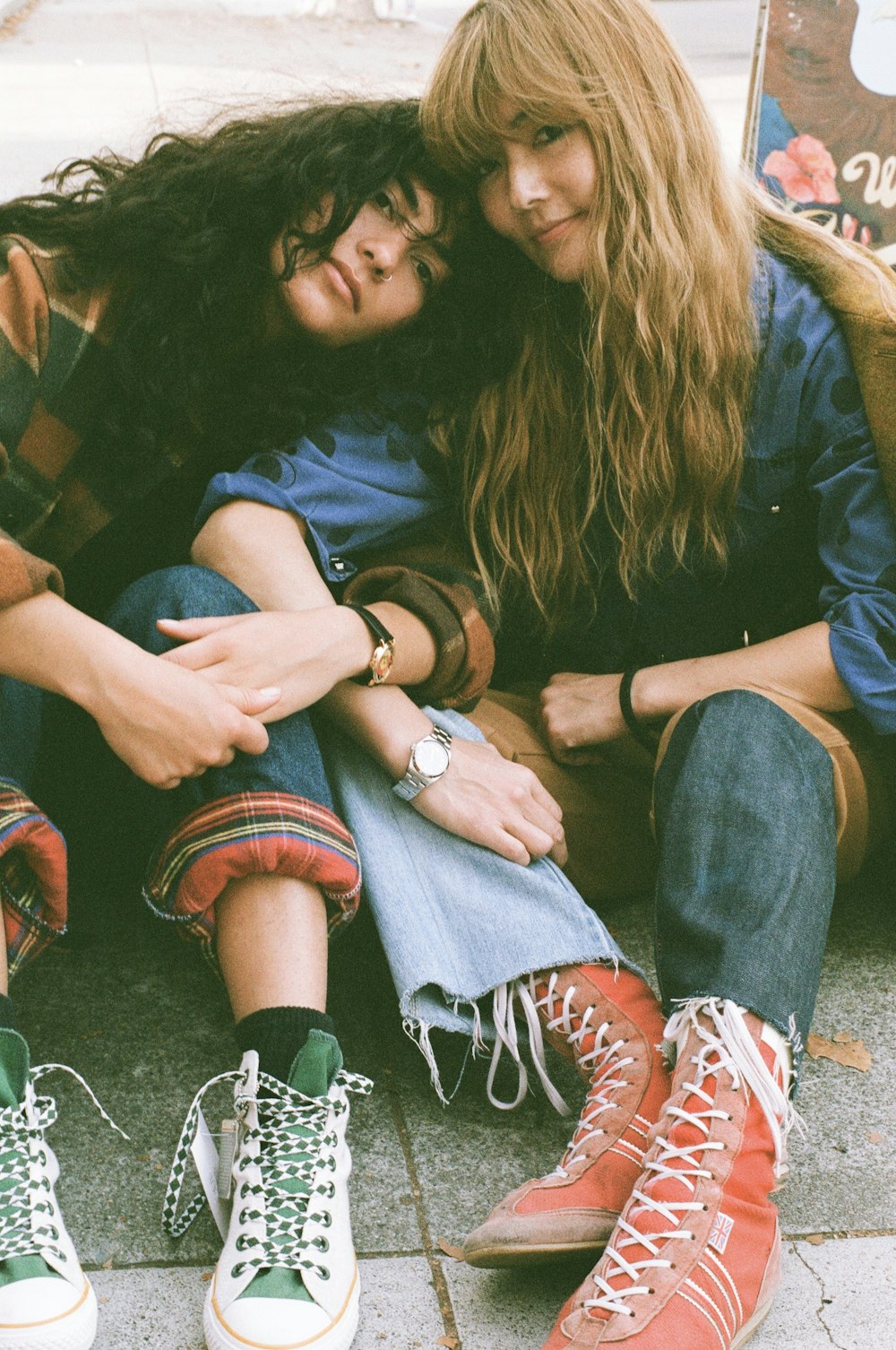 두 소녀가 서로 팔을 감싸고 땅에 앉아 있다