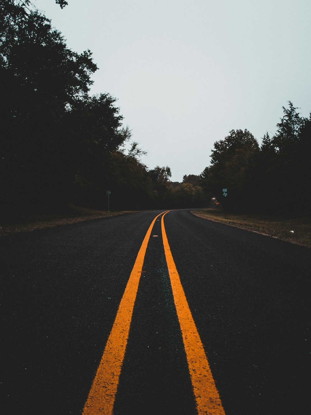 an empty road with two yellow lines on it