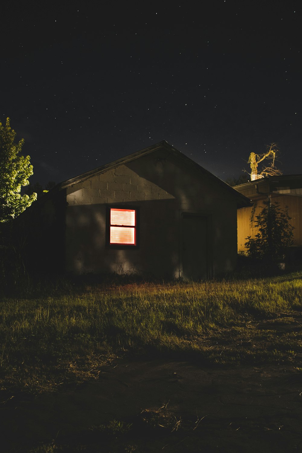 a small house sitting in the middle of a field at night