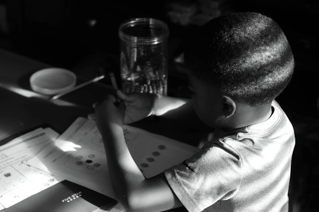 A close-up of a child’s hands holding a pencil, focused on their schoolwork.