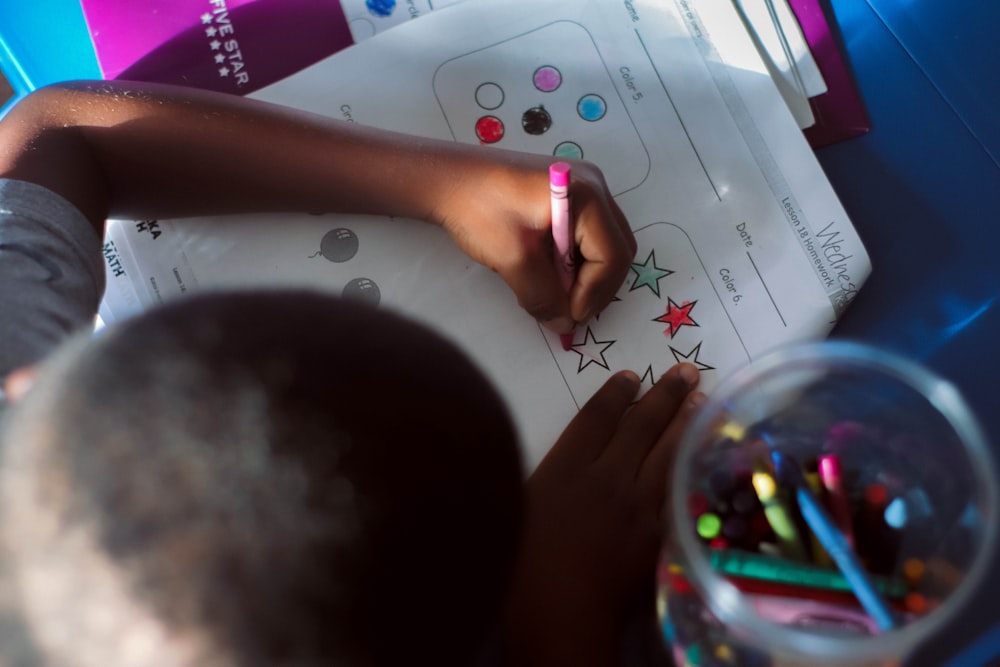 a child is doing something on a sheet of paper