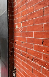 a red brick wall with a heart drawn on it