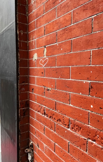 a red brick wall with a heart drawn on it