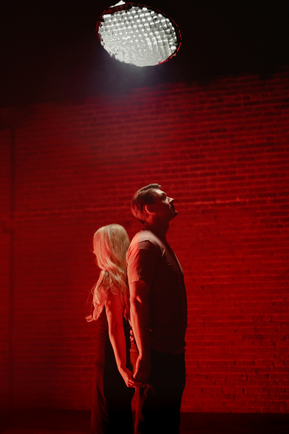 a man and a woman standing in front of a red light