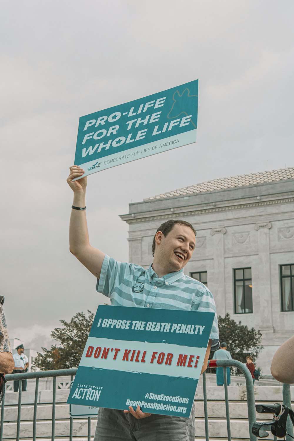 a man holding a sign that says pro life for the whole life